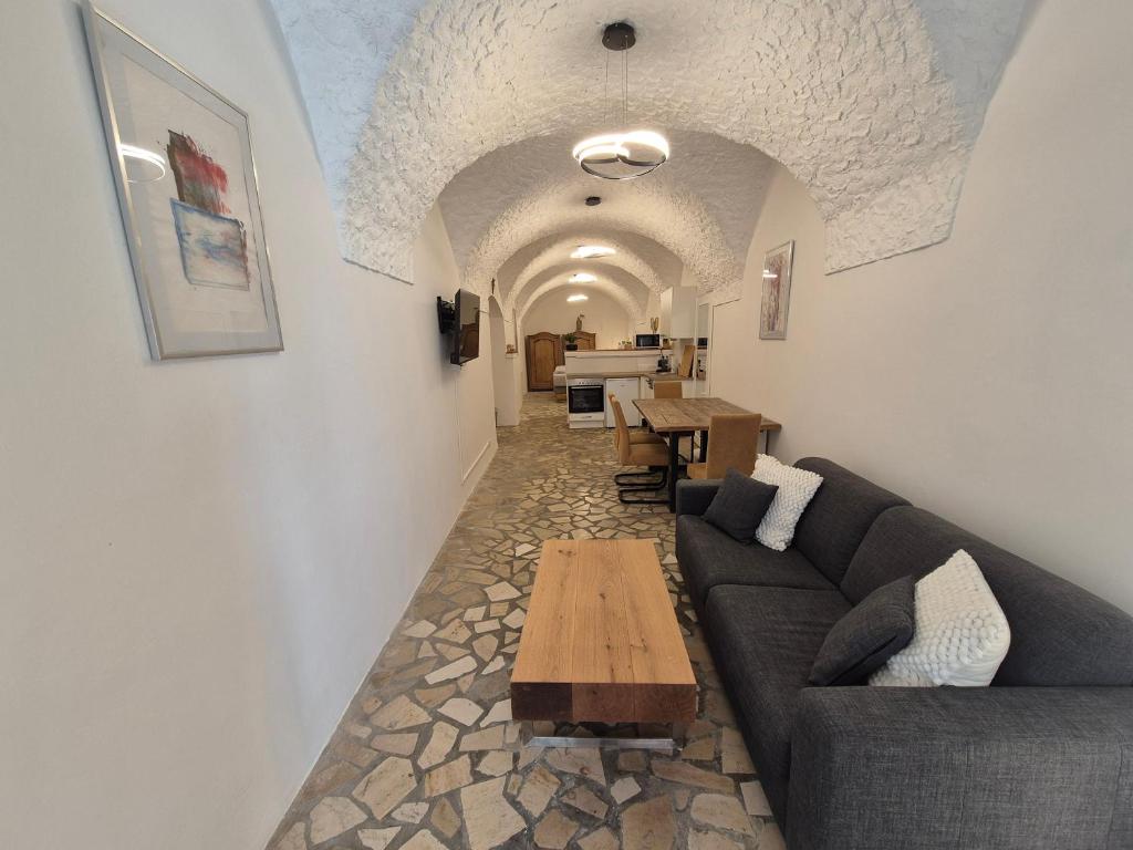 una sala de estar con un sofá y una mesa en Charmantes Brauerei-Altstadtgewölbe, en Laufen