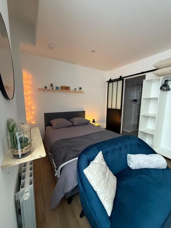 une chambre avec un lit et un canapé bleu dans l'établissement Le Cosy, à Rochefort