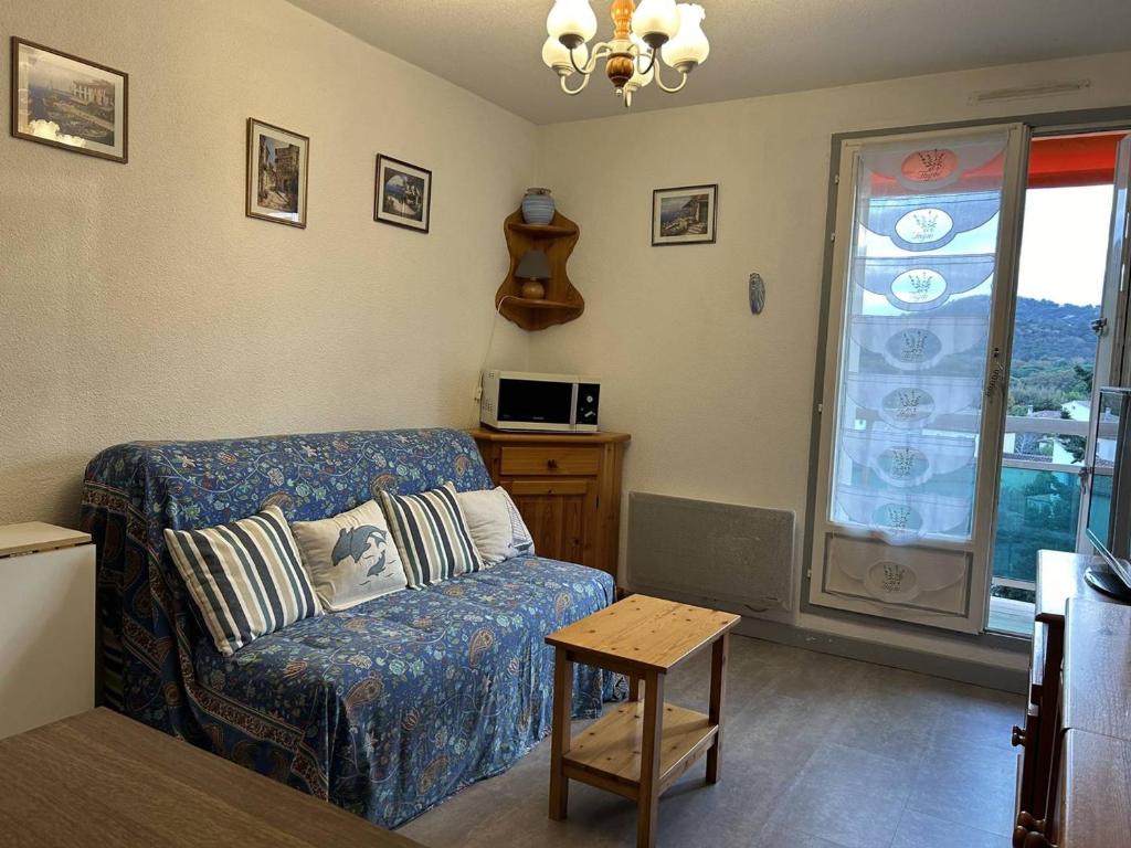 un salon avec un canapé et une fenêtre dans l'établissement Appartement cosy à 350m de la plage avec balcon et garage - Bormes-les-Mimosas - FR-1-251-724, à Bormes-les-Mimosas