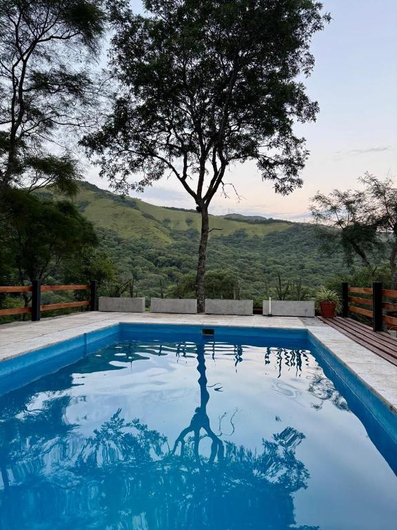 a pool with a reflection of a person in the water at Mis Cabañas La Misión in Salta