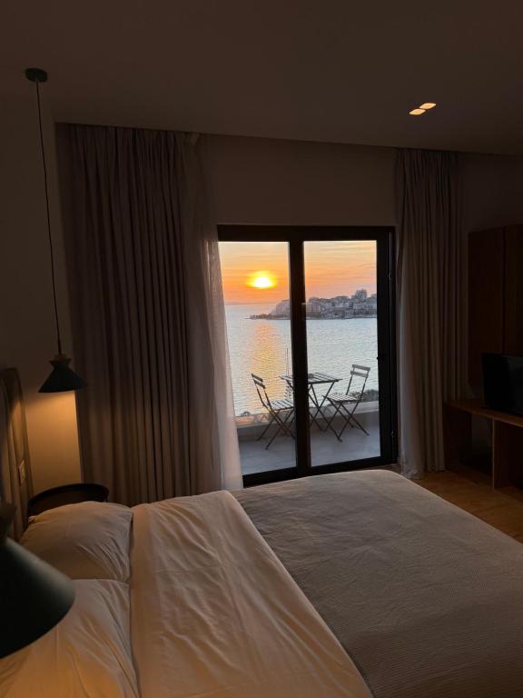 a bedroom with a bed and a view of the ocean at Kanes Bohemian Boutique Hotel in Sarandë