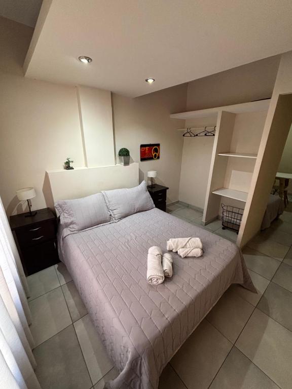 ein Schlafzimmer mit einem Bett, auf dem zwei Handtücher liegen in der Unterkunft Rivadavia Departamentos in Mendoza