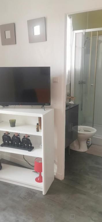 La salle de bains est pourvue d'une télévision sur un meuble blanc. dans l'établissement Les fees mer, à Marseille