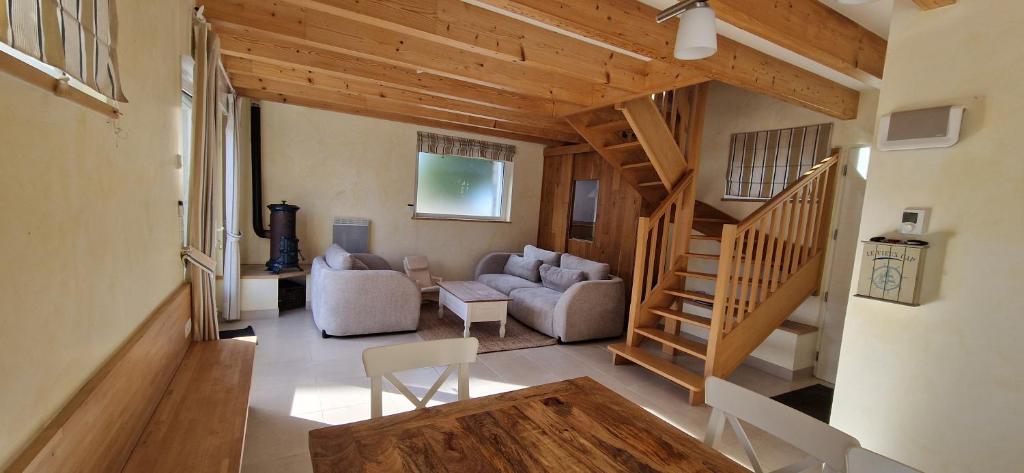 Una sala de estar con un sofá y una escalera. en Havre de paix près des plages, en Arzon