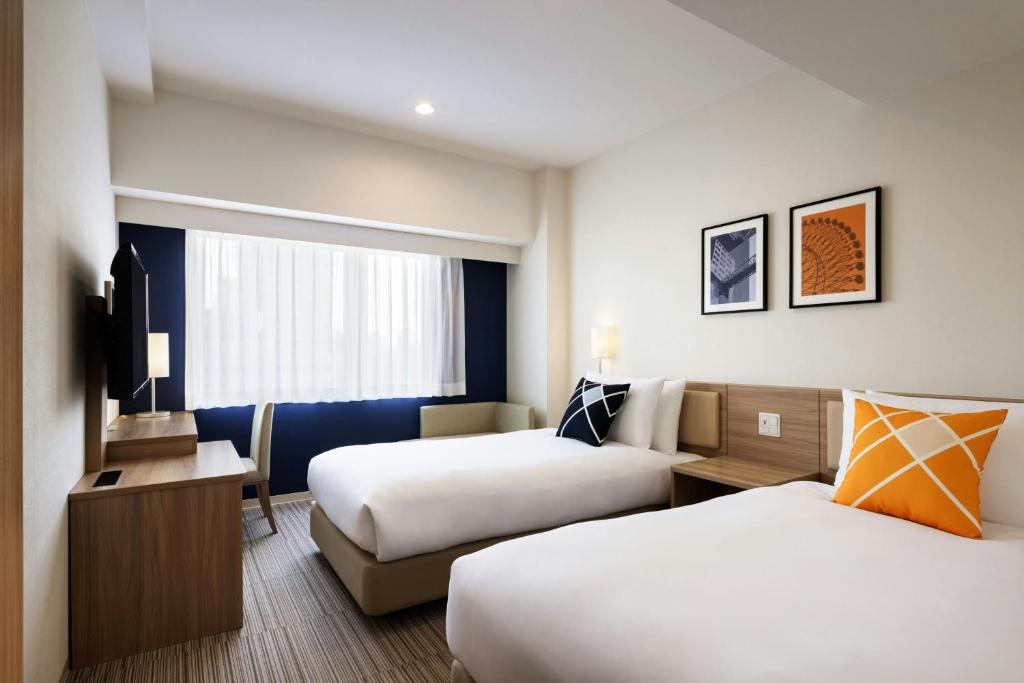 Postel nebo postele na pokoji v ubytování Four Points Flex by Sheraton Shin Osaka
