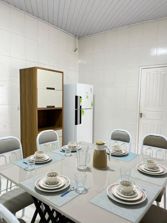 ein weißer Tisch mit Stühlen und ein weißer Kühlschrank in der Unterkunft Casa Açaí in Bragança