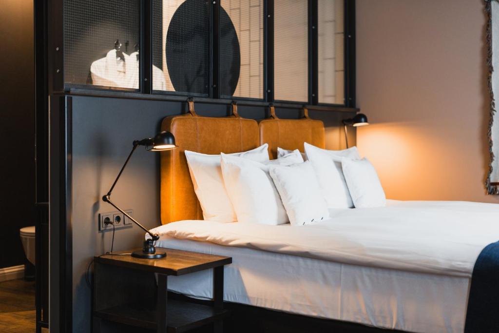 una habitación de hotel con una cama con una lámpara en una mesa en Exeter Hotel, en Reikiavik
