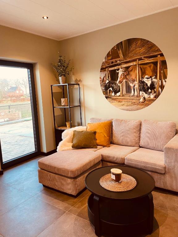 a living room with a couch and a table at de Loeiende koe in Liessel