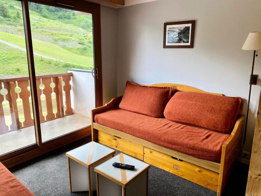 un salon avec un canapé et une grande fenêtre dans l'établissement Résidence Les Sentiers du Tueda - maeva Home - Studio 4 personnes - Sélection MAE-1151, à Les Allues
