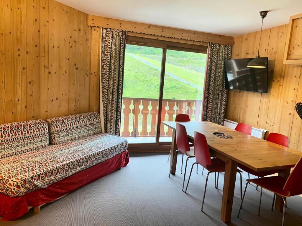 Cette chambre comprend un lit, une table et une télévision. dans l'établissement Résidence Les Sentiers du Tueda - maeva Home - Appartement 5 pièces 8 personnes - Sélection MAE-1401, à Les Allues