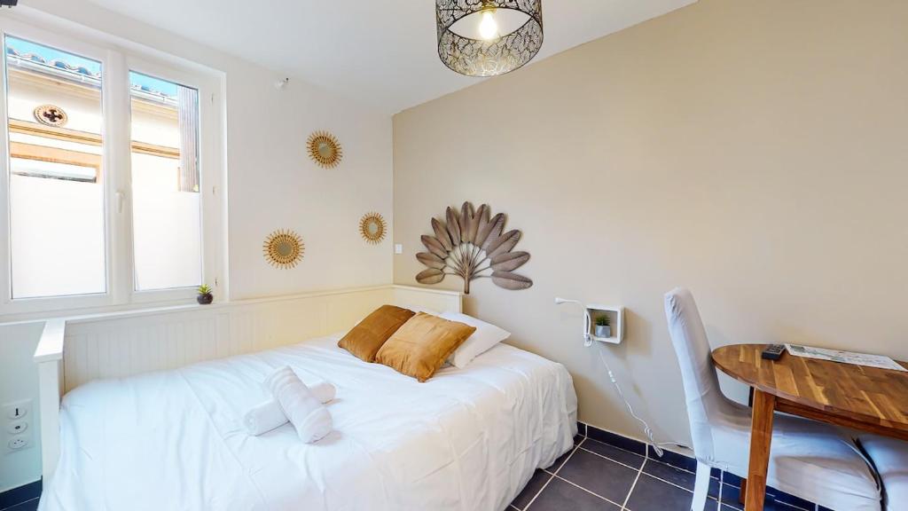 - une chambre avec un lit blanc et une table en bois dans l'établissement Studio Pouvillon proche Zenith - Centre Toulousain, à Toulouse