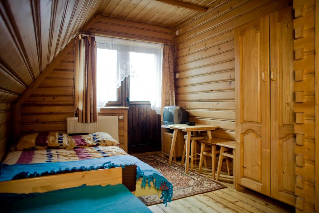 ザコパネにあるPokoje Gościnne U Jaśkaの木造キャビン内のベッド1台が備わるベッドルーム1室を利用します。