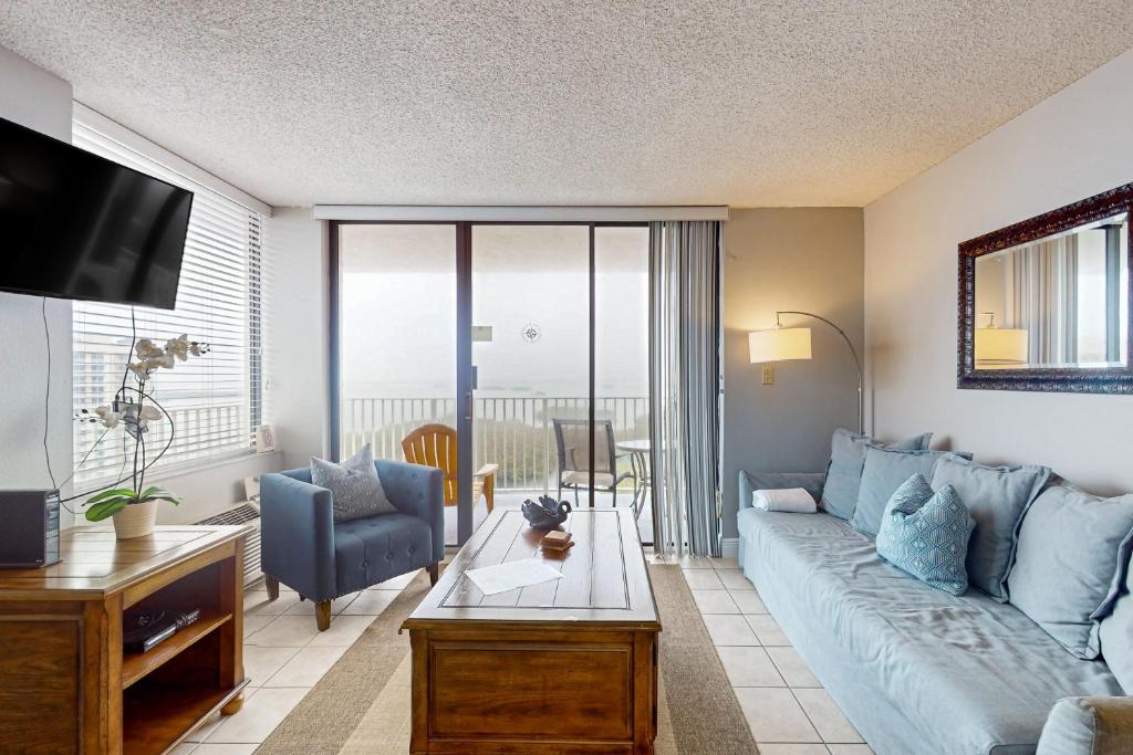 a living room with a blue couch and a table at Lover's Key Oasis in Fort Myers Beach