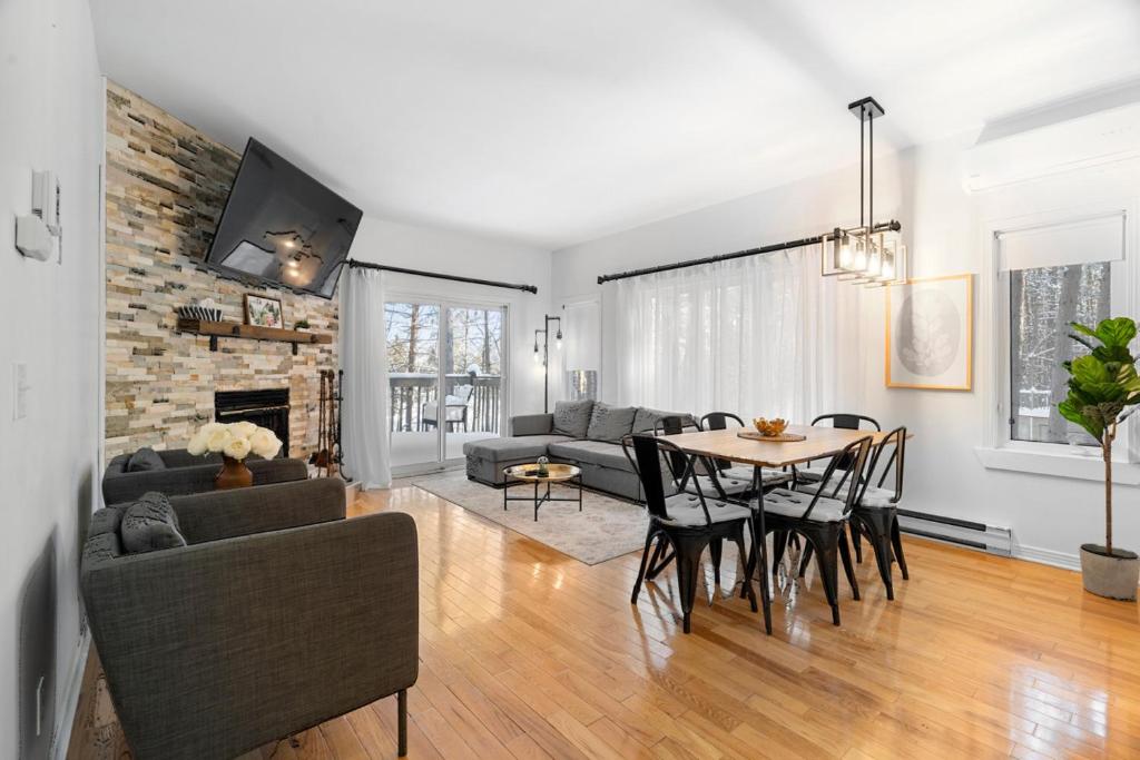 a living room with a table and a couch at Chez Dodo Chalet Tremblant 3bdrs condo with fireplace in Mont-Tremblant