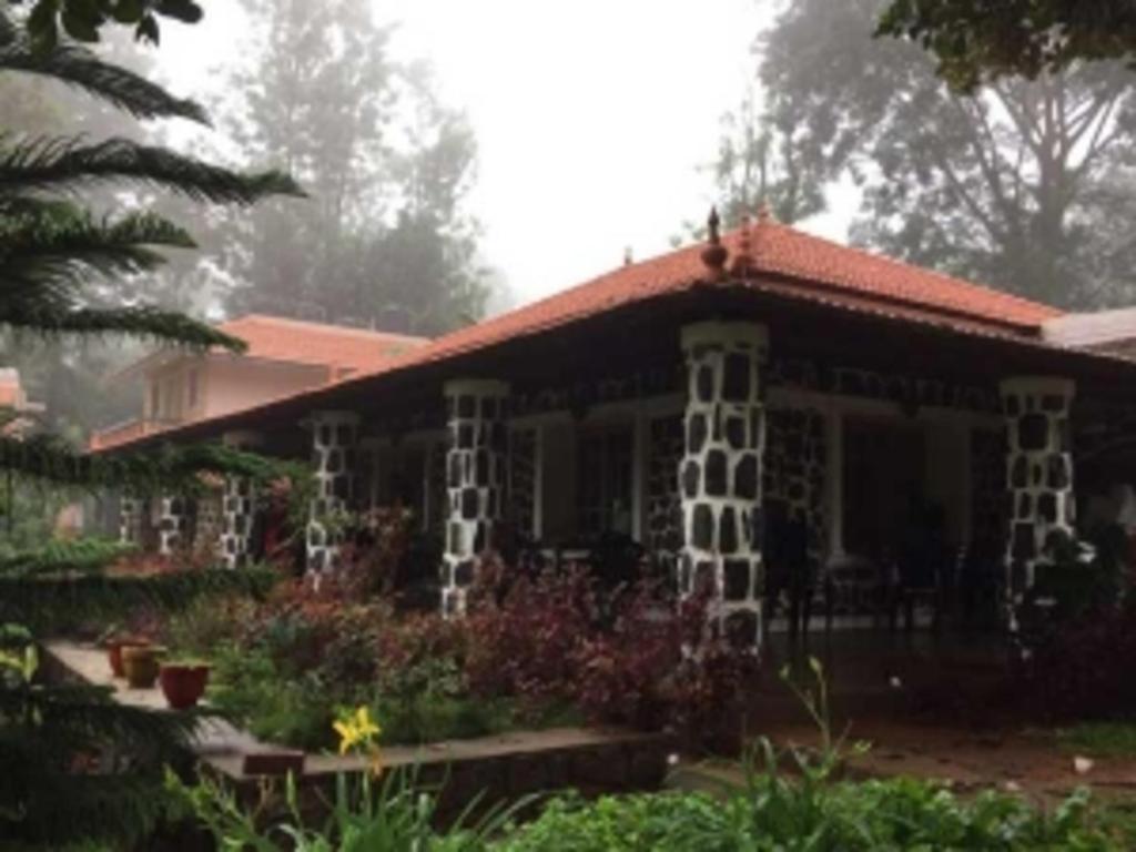 a house with a garden in front of it at Coastal Grand JMA Resorts, sirumalai in Ambātturai
