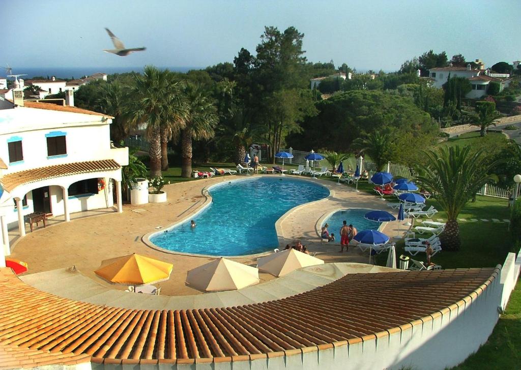 uma vista para uma piscina com guarda-sóis em Turiquintas em Armação de Pêra