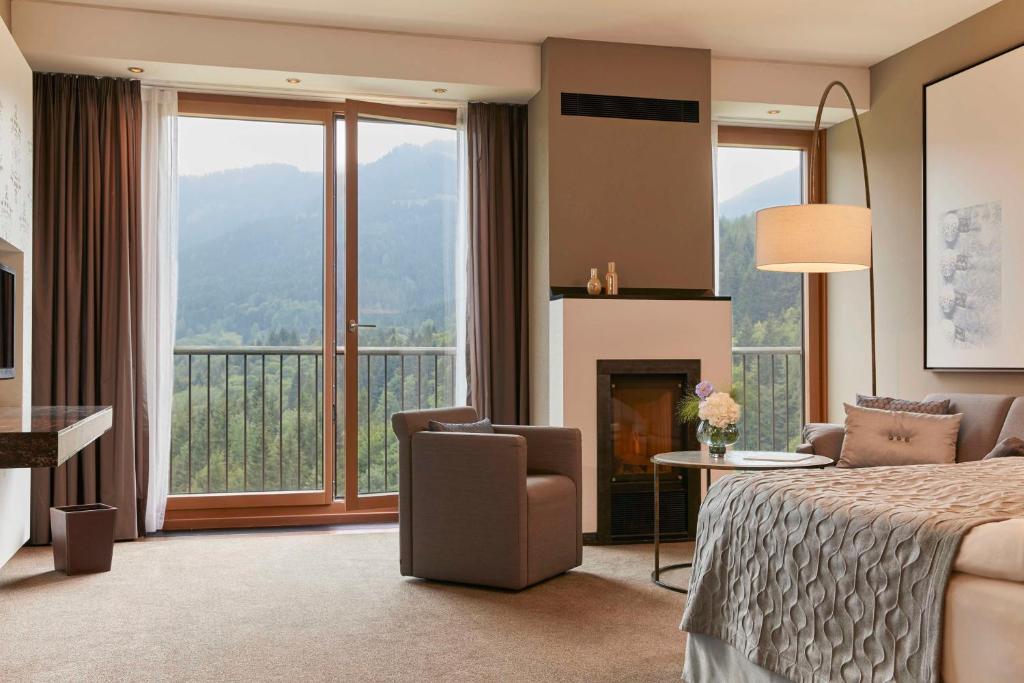 a hotel room with a bed and a fireplace at Kempinski Hotel Berchtesgaden in Berchtesgaden