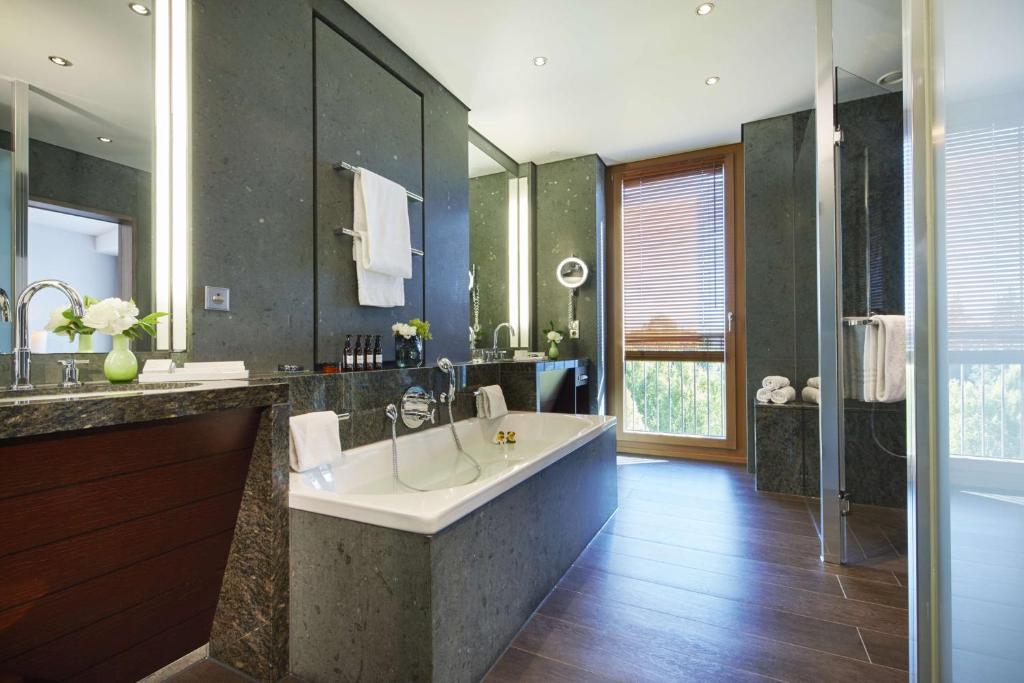 a large bathroom with a tub and a shower at Kempinski Hotel Berchtesgaden in Berchtesgaden