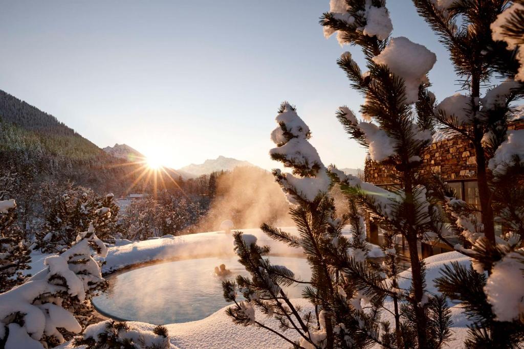 a snow covered mountain with the sun in the background at Kempinski Hotel Berchtesgaden in Berchtesgaden