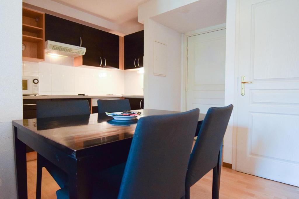 a kitchen with a dining room table and chairs at Residhotel Mulhouse Centre in Mulhouse