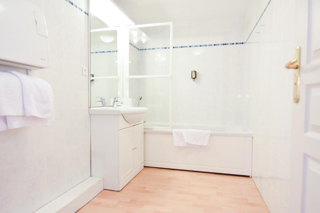 a white bathroom with a shower and a sink at Residhotel Mulhouse Centre in Mulhouse