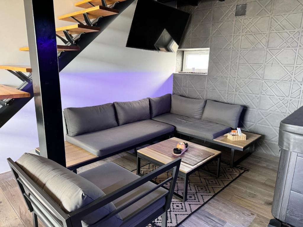 una sala de estar con un sofá y una mesa en Love Room Spa - Sauna - Hammam, en Domérat