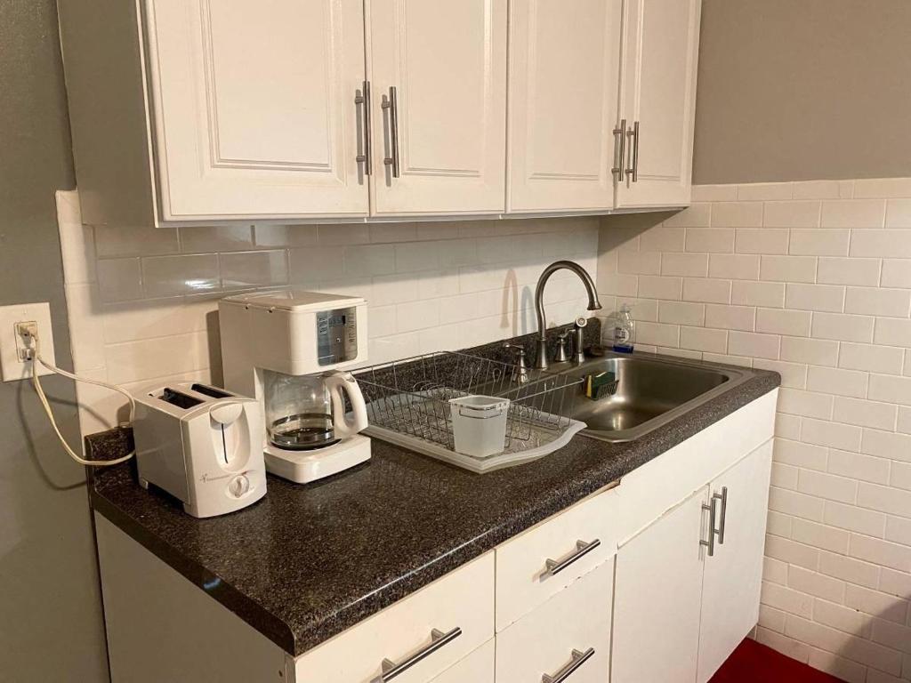 a kitchen counter with a sink and a microwave at Cozy 1 BR, walk to subway, Free WiFi & Parking in Belleville