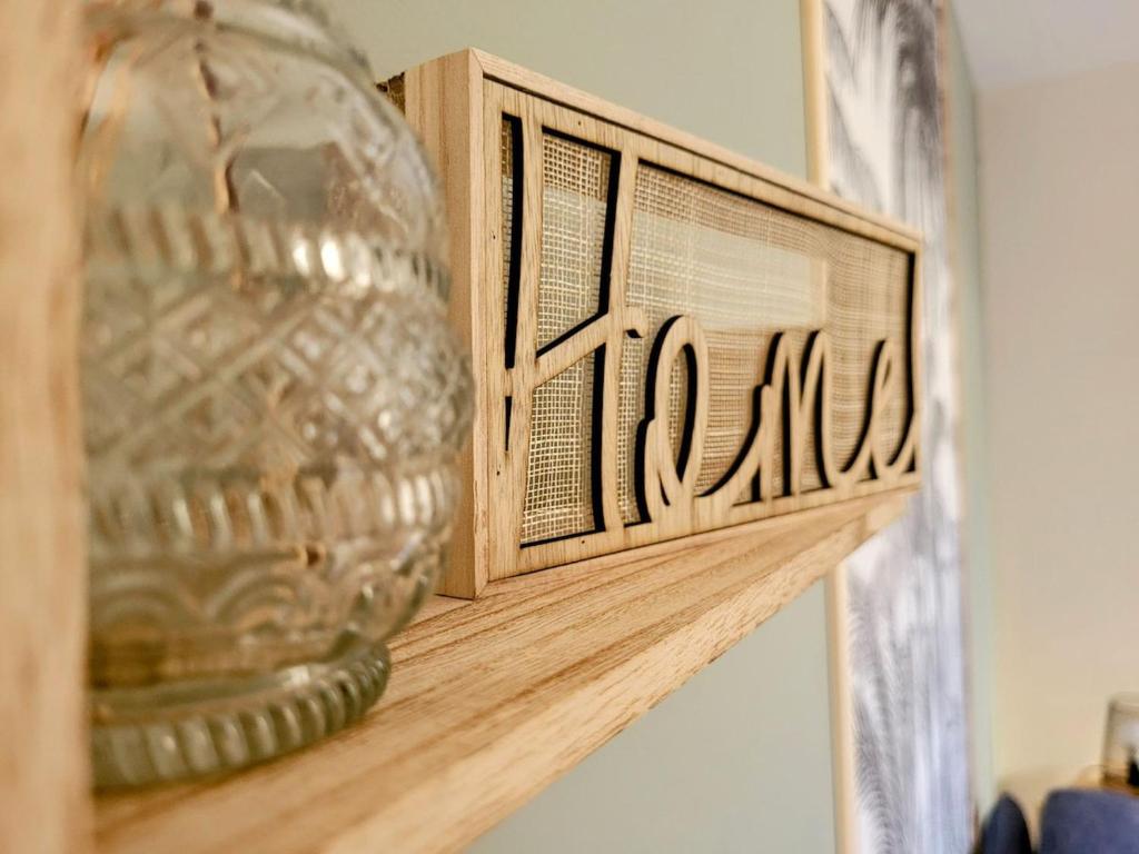 un vase en verre assis au-dessus d'une étagère en bois dans l'établissement T2 Proche plage aux phoques avec parking, à Berck-sur-Mer