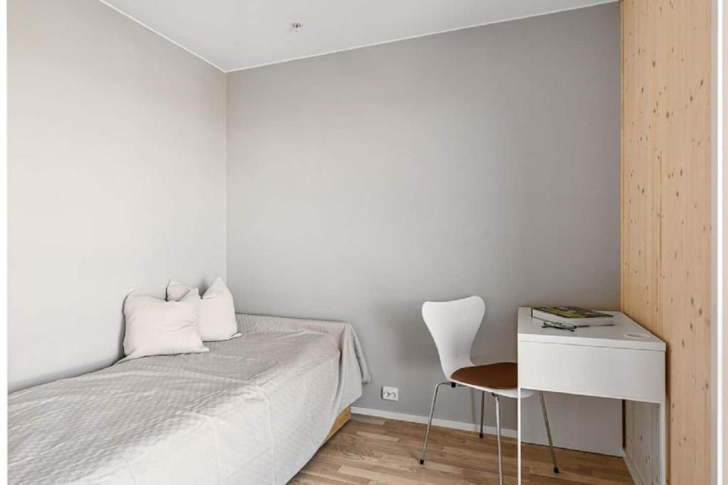 a bedroom with a bed and a desk and a chair at 5,1sq mts room -Forests cozy house in Stavanger