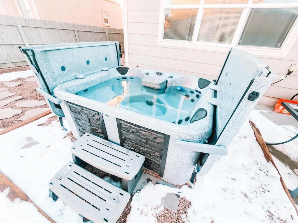 a hot tub sitting on a patio with two chairs at Hot Tub, King Beds, Pet Friendly Close to I25 in Fountain