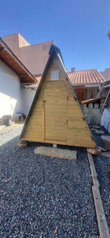 a large wooden building with a door on the ground at Ecox Hostel Cabanas 2 in Penha