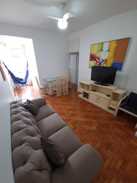 a living room with a couch and a flat screen tv at Apê com 2 quartos super bem localizado em copa in Rio de Janeiro