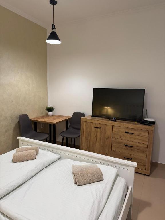 un soggiorno con 2 letti e una TV a schermo piatto di Apartman Cute&Cosy a Sombor