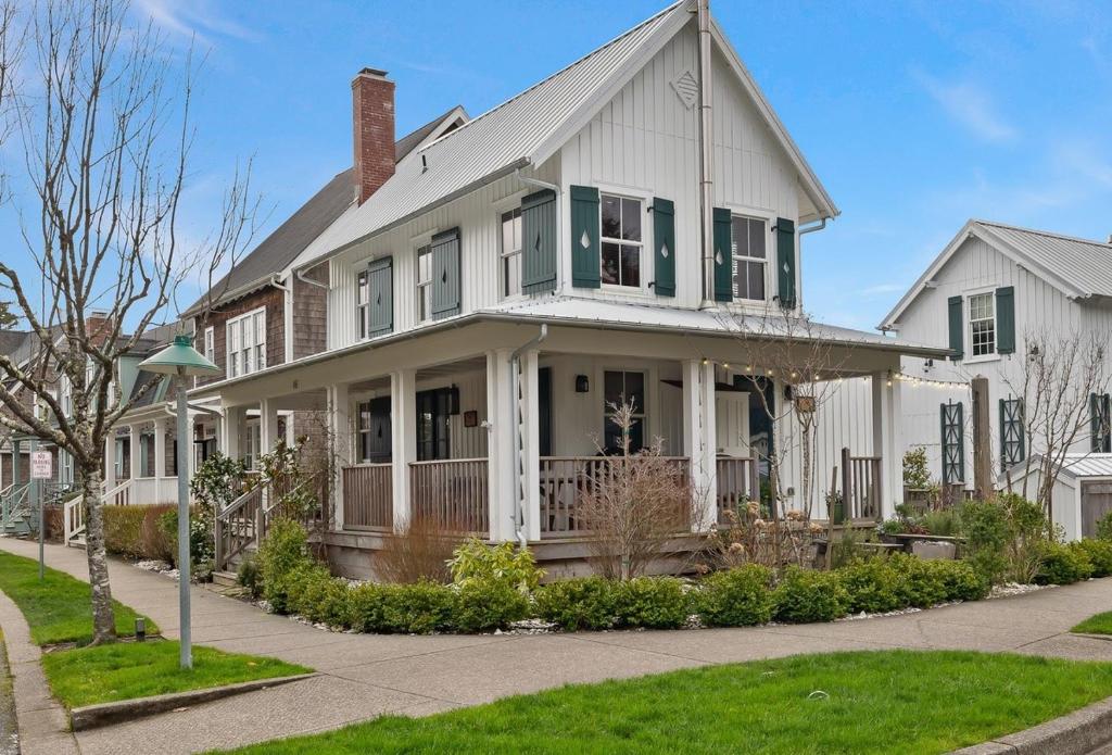 una casa bianca con persiane verdi su una strada di Cedarbrook Cottage by Seabrook Hospitality a Pacific Beach