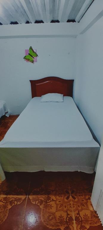 a white bed in a white room with at Hostal la 18 in Pereira