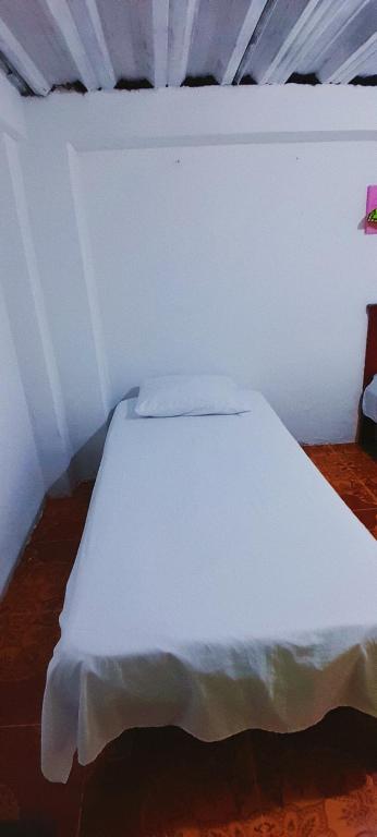 a bedroom with a white bed in a room at Hostal la 18 in Pereira