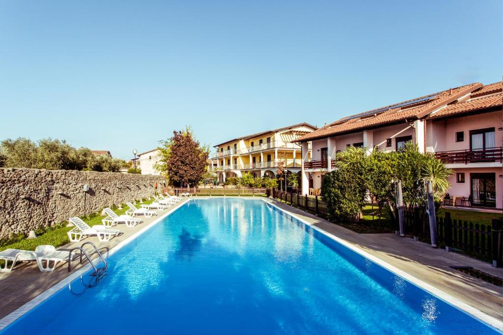 einen Pool mit Liegestühlen neben einem Gebäude in der Unterkunft Hotel Splendid Sole in Manerba del Garda