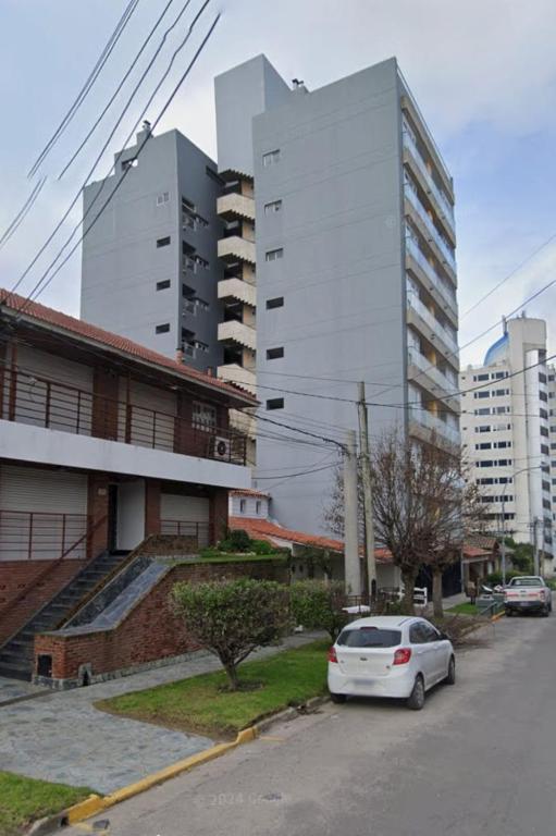 a white car parked on a street with tall buildings at Ale-MardelPlata-Sicilia in Mar del Plata