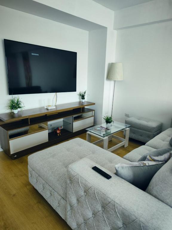a living room with a couch and a flat screen tv at Depa Bonito en Condominio ! in Tacna