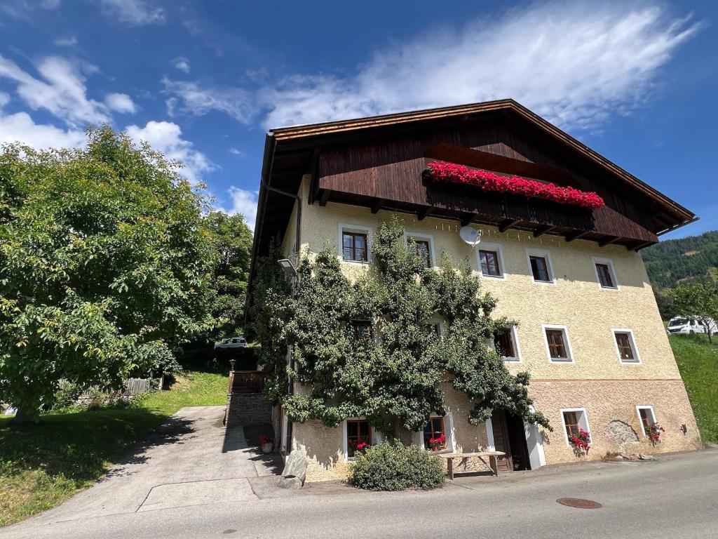 a building with red flowers on the top of it at Unterhecherhof in Bannberg