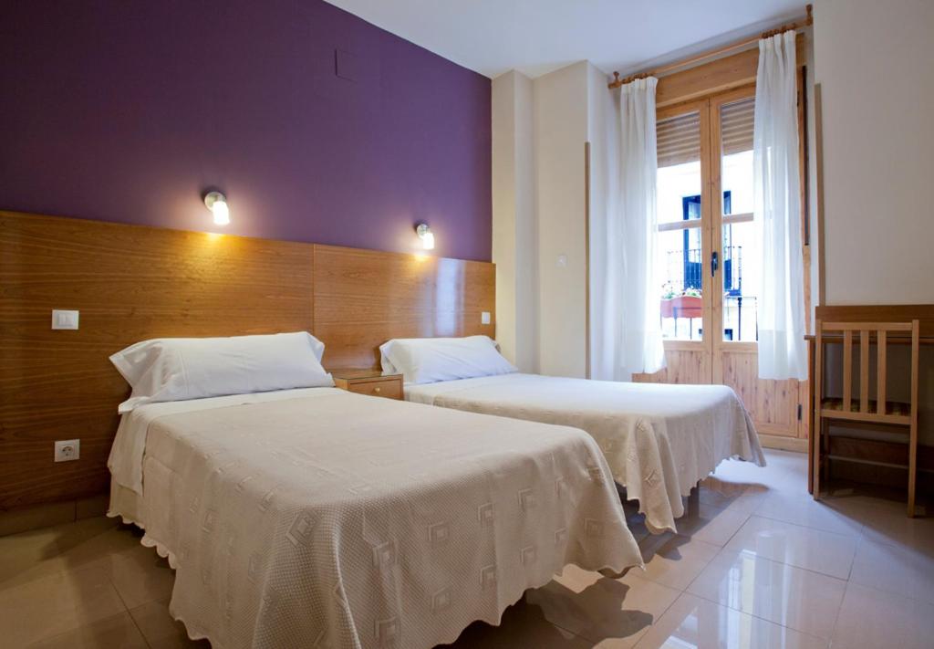 マドリードにあるホステル ザバラの紫の壁のベッドルーム1室(ベッド2台付)