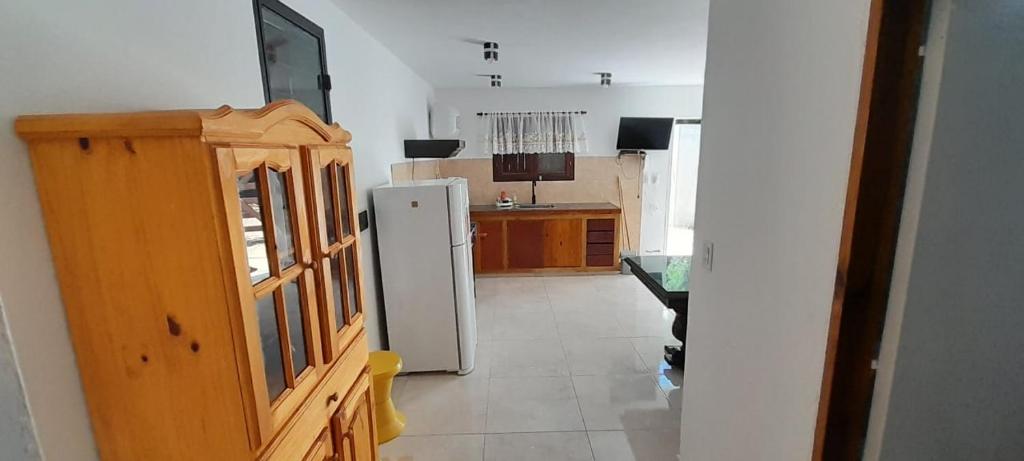 Una cocina con un refrigerador blanco en una habitación. en Plácida, en Villa Gesell