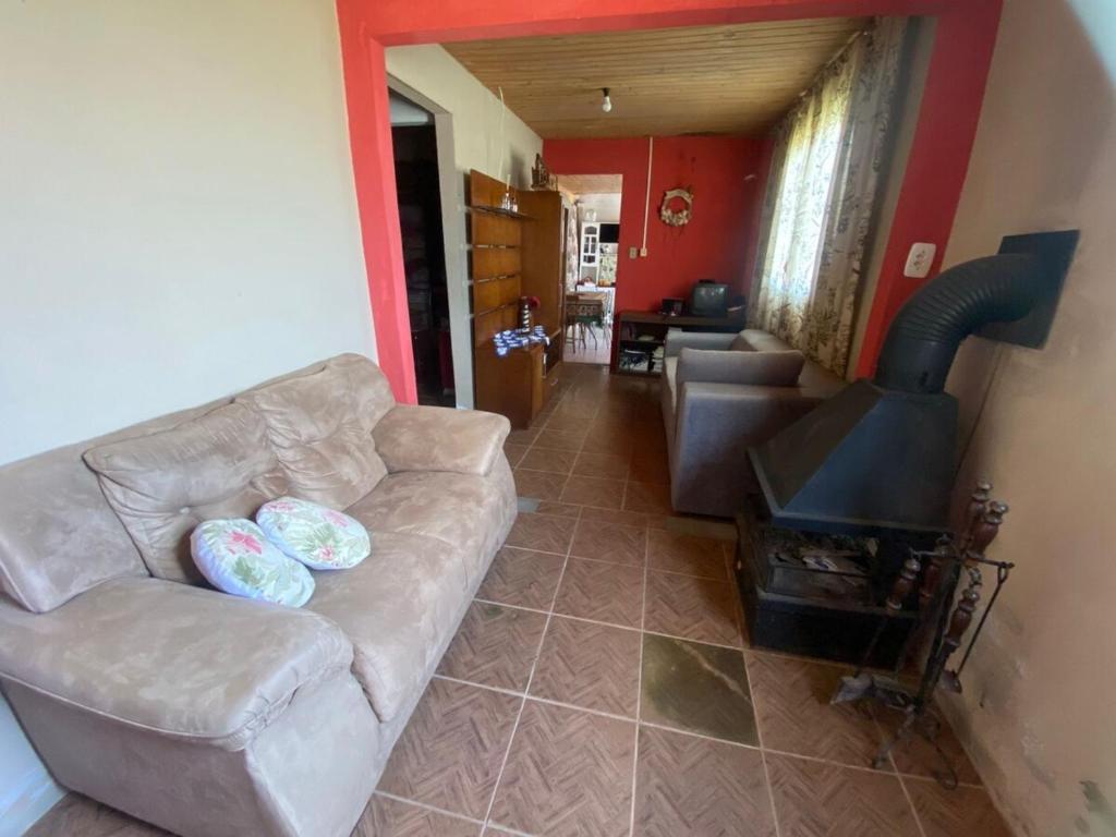 a living room with a couch and a stove at Casa Completa para Hospedagem in Rosário do Sul