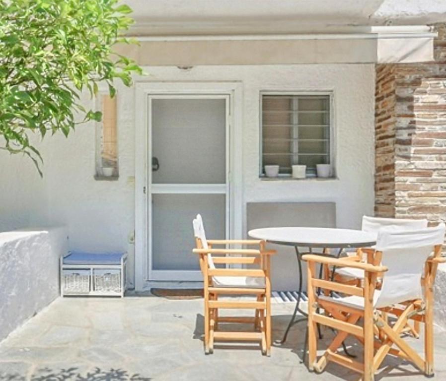 a patio with a table and chairs in front of a door at Agistri House Pefkohori in Pefkochori