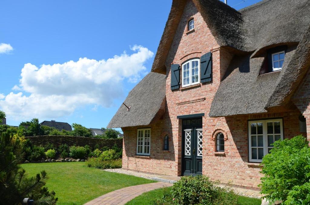 an old brick house with a thatched roof at LITZKOW 12802 in Morsum