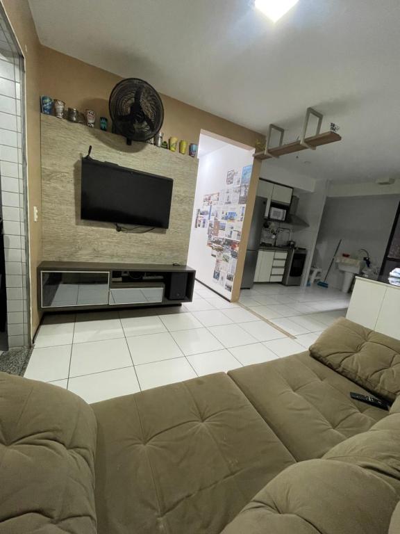 a living room with a couch and a flat screen tv at Próx a praia in São Luís