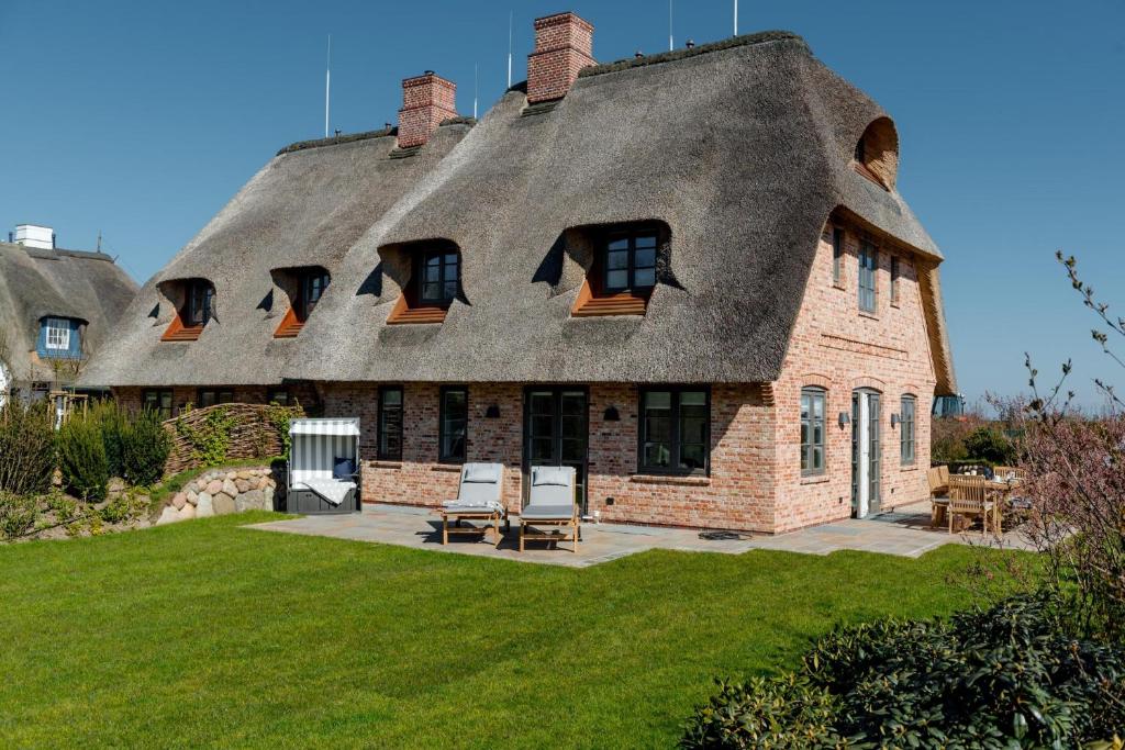 una casa con tetto di paglia e cortile di LITZKOW 16205 ad Archsum