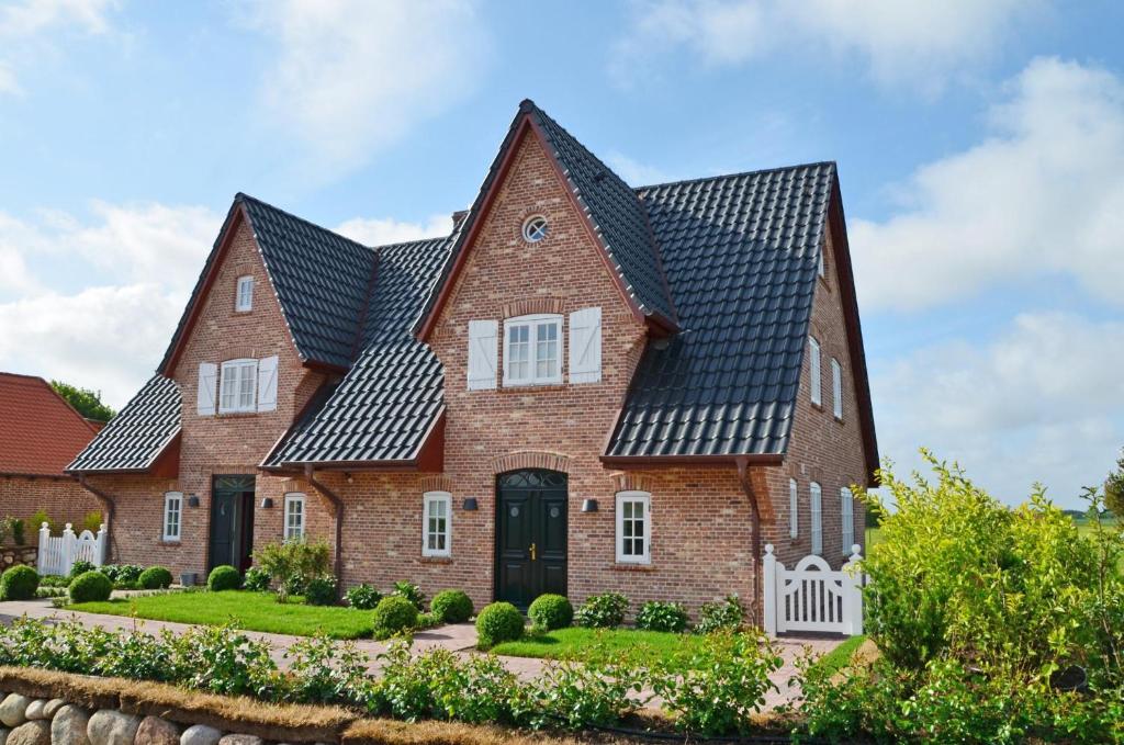 una grande casa in mattoni con tetto nero di LITZKOW 12503 a Morsum