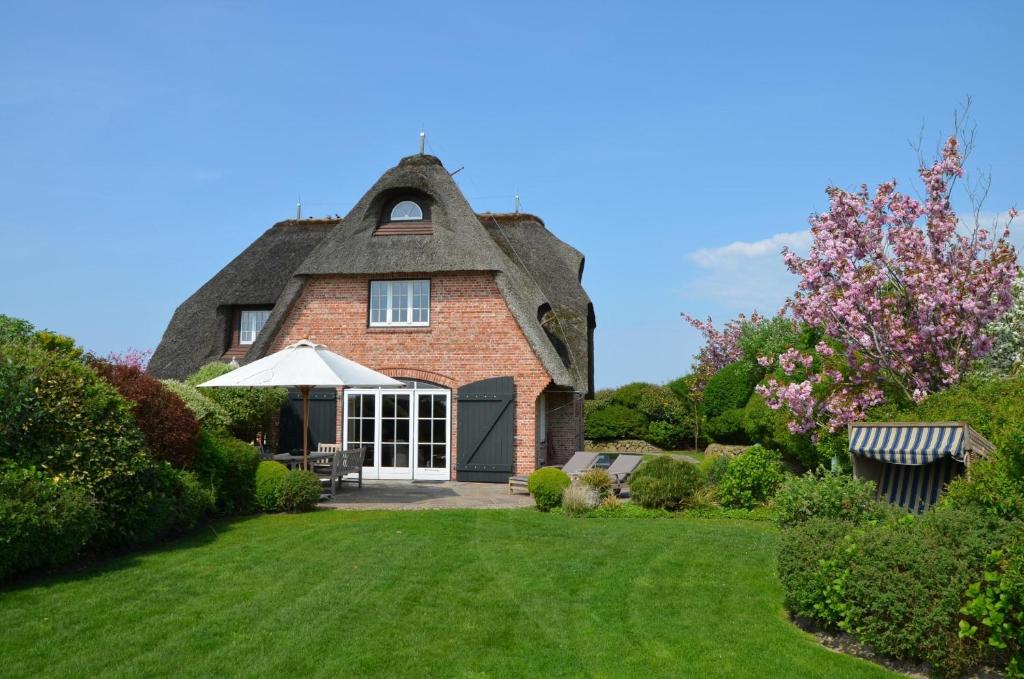 una vecchia casa con tetto di paglia e cortile di LITZKOW 12601 a Morsum