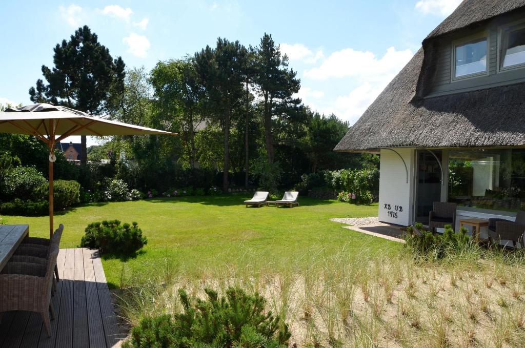 a yard with two chairs and an umbrella at LITZKOW 19201 in Keitum